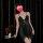 A woman poses elegantly in a black sheer mesh bralette sleep dress featuring lace trim and a side slit, exuding sensuality ag...