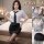 Woman modeling white sheer secretary-style shirt with black tie, mini skirt, and stockings – pure & seductive lingerie set.