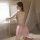 Woman in pink lace mesh sleep set on bed, sheer tempting slip-on lingerie for small bust.