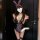 Woman wearing a purple and black lace bunny girl lingerie set with ears, choker, and stockings for romantic nights.