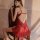 A woman sits on a chair wearing a red lace cami sleep dress with underwire support, featuring a flirty design perfect for sma...