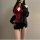 Woman wearing red lace halter bodysuit under black jacket, paired with mini skirt — flirty, body-conscious lingerie-inspired ...