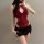 Woman wearing red lace halter bodysuit with black mini skirt, showcasing body-conscious lingerie-inspired fashion for layerin...