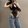 Woman wearing black lace halter bodysuit with jeans, showcasing flirty cropped design perfect for layering and body-conscious...