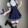 A stylish ensemble featuring a navy blue pleated suspender skirt with white trim, paired with a light blue blouse and black k...