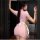 A woman models a pink nurse costume set featuring a bodycon skirt with lace-up back details and a white bow, perfect for cosp...