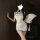 A woman poses elegantly in a chic, high-slit cheongsam dress made from silky fabric. she holds a delicate fan, adding to the ...
