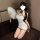 A woman poses elegantly in a white cheongsam, featuring a high slit and delicate lace details. she holds a fan, adding to the...