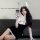 A stylish woman poses with bunny ears and lace gloves, wearing a black bodycon dress with white lace details. the outfit feat...