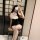 A woman poses with a heart-shaped filter on her phone, wearing a black lace bodysuit dress paired with white stockings and bu...