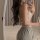 Woman in pure temptation lace bodysuit, sheer romantic lingerie with open back, holding wine glass in bedroom mirror selfie.