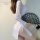 A woman poses elegantly in a sheer white lace cheongsam, featuring a high slit and delicate black lace fan. the vintage desig...