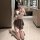 A woman poses in a bathroom wearing a sexy backless jk schoolgirl outfit from pure temptation, featuring a bow tie and skirt,...
