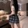 A woman poses in a modern bedroom wearing a cute japanese school uniform set, featuring a plaid skirt and playful top, embody...