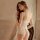 Woman wearing pure & tempting lace bodysuit for small bust - sheer, open-crotch sleepwear with bow detail, elegant and sexy.