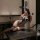Woman wearing leopard print lingerie set with bunny ears, posing seductively on a table in a dimly lit room.