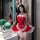 A woman poses in a festive christmas-themed sleepwear outfit, featuring a red maid costume with lace details and a santa hat,...
