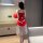 A woman stands facing away from the camera, wearing a festive red christmas-themed dress with white accents and tulle skirt. ...