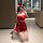 A woman poses in a festive red dress with white accents, resembling a santa hat, capturing herself in a mirror. the outfit fe...