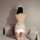 Woman wearing white bunny girl lingerie set with open-crotch design, sheer back, and fluffy tail detail.