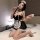 A woman poses elegantly in a black and white maid outfit, featuring lace details and fishnet stockings, holding a cup and spo...