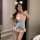 A woman poses in a sheer bodysuit with lace details and bows, featuring an open crotch design, perfect for a cute and seducti...