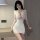 A woman poses in a white, deep v-neck sheer bodice dress with lace detailing, exuding elegance and allure. perfect for a soph...