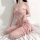 Woman wearing pink lace sleepwear set with sheer mesh cami and shorts, designed for small bust enhancement.