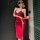A woman poses in a striking red qipao-inspired bodysuit with lace detailing and a thigh-high slit, paired with gloves and a m...