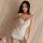 A woman poses in a purple floral lace sleep dress, featuring adjustable straps and soft satin trim, perfect for summer nights...