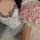 A woman wears a purple floral lace sleep dress, featuring a tight fit and delicate lace details, holding a bouquet of pink ro...
