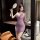 A woman poses elegantly in a sheer purple lace bodysuit set, featuring delicate floral accents and a classic design. the sens...