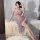 Woman posing in purple lace halter lingerie dress with open-crotch design, sheer fabric, and floral hair accessory.