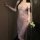 A woman poses elegantly in a sheer purple lace sleepwear dress, featuring off-the-shoulder design and floral patterns. the fl...