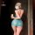 A woman stands facing away from the camera, wearing a blue lace sleep dress with a heart-shaped cutout on her face. the outfi...