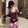 Woman wearing purple lace lingerie set with embroidered sheer bra, panty, gloves, and thigh-highs in bathroom.