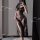 Woman wearing sheer black lace nightdress with high slit, floral pattern, and strap design—elegant sexy lingerie set.