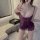 Woman modeling purple lace slip dress with adjustable straps and cutouts in bathroom setting.