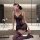 A woman poses in a luxurious bathroom wearing a purple lace sheer sleep dress. the off-shoulder design features floral trim a...
