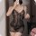 Woman wearing sheer black lace lingerie sleep dress, flirty and feminine bedroom outfit with floral details.