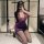 A woman poses in a purple ol secretary outfit featuring deep v lace, sheer tight bodycon skirt, and black stockings, holding ...