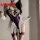 Woman modeling a purple bodysuit with white lace trim and sheer ruffles, paired with matching garters.