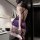 Woman wearing purple bodycon lingerie set with garter straps, back view showing seductive design and high heels.