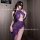 Woman wearing purple sheer lace lingerie set with open-crotch mesh bodysuit and high slit, posing in a stylish room.