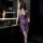 Woman wearing purple sheer lingerie set with deep v neck and lace waistband in modern bathroom.