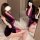 Woman in purple velvet qipao lingerie set with deep v-neck and tie-back, posing seductively on white rug.