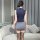 Woman wearing navy pxfs secretarial bodysuit skirt with gray mini skirt and black thigh-highs, viewed from behind in elegant ...