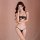 Woman modeling qiao hu niang black lace lingerie set with sheer bra and open-crotch panty against soft pink backdrop.