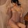 Woman wearing qing lian yi plus size lingerie set with lace slip dress and matching robe, seated by sheer curtains.