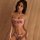Woman wearing pink qing lian yi camisole bodysuit set with playful text and lace trim, sheer straps, matching thong.
